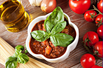 Salsa Boloñesa, tomates y un vaso de aceite
